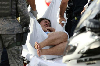 An unidentified male is taken away on a stretcher outside the main gate at Joint Base Pearl Harbor-Hickam on Dec. 4, 2019, in Hawaii, following a shooting. 